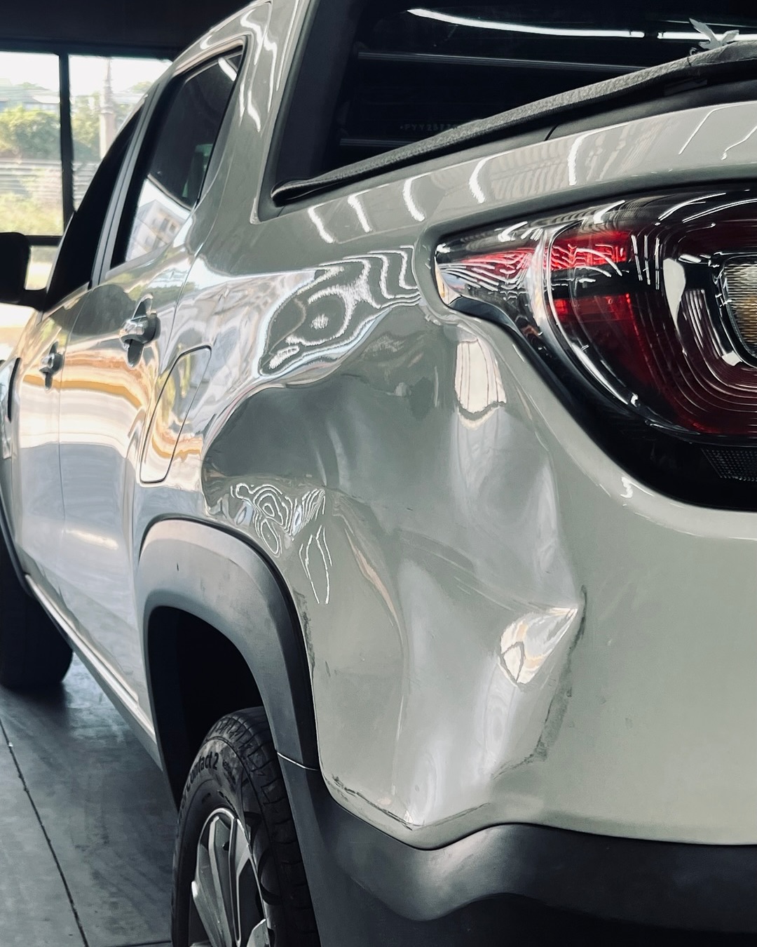 Lateral traseira de SUV branco amassada antes do martelinho de ouro